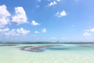 Ocean view with shallow light turquoise water and blue sky in Caribbean sea. Travel natural background. Tropical island view. Vacation recreation.