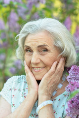 Close-up portrait of happy senior beautiful woman on lilacs background