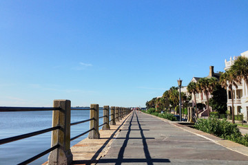 Obraz premium Charleston, South Carolina/USA - Sep 03, 2016: Boardwalk with houses on one side and sea on the other side in Charleston port. Sunny view at the Charleston bay.