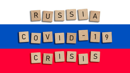 Russia Covid 19 crisis written with wooden tiles over Russian flag background