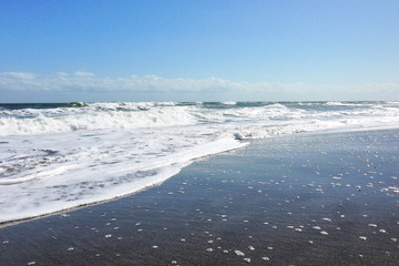 Fototapeta premium Cocoa Beach, Florida/USA - Nov 5, 2016: Picture of the sandy beach in Florida. Huge waves and dark sand on Cocoa Beach at sunny weather.