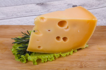 Maasdam cheese  in the board served salad leaves