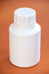 White Plastic Pill Bottle On A Wooden Surface
