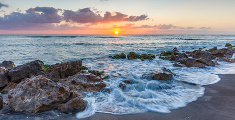 Sunset over the rocky shore of the Gulf of Mexico at Caspersen Beach in Venice Florida