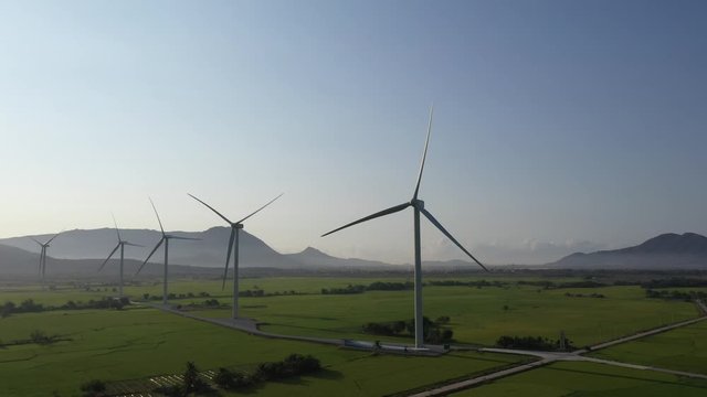 Aerial view of windmills farm for energy production on rice field, Dam Nai, Ninh Thuan, Vietnam. Wind power turbines generating clean renewable energy for sustainable development