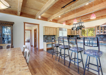 Large country home with open kitchen with wood beam ceiling and grey stone.