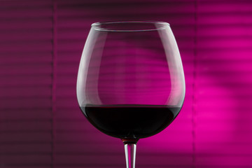 glass of french wine on a rose background.