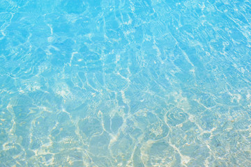 Shining blue water ripple background. Surface of water in swimming pool.