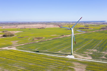 Windmill on a background of green field. Green electricity production. Alternative energy.
