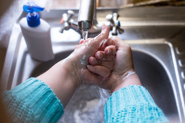 Girl washing hands with liquid soap