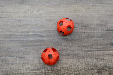 two red origami paper balls on wooden