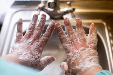 antibacterial soap. Girl washes hands with soap.