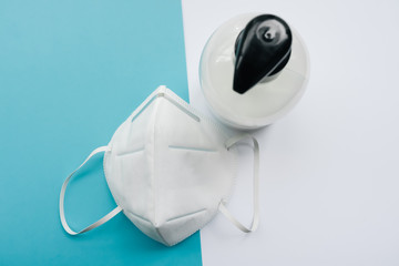 Mask that protects from the coronavirus and soap to avoid contagion. White and turquoise background.