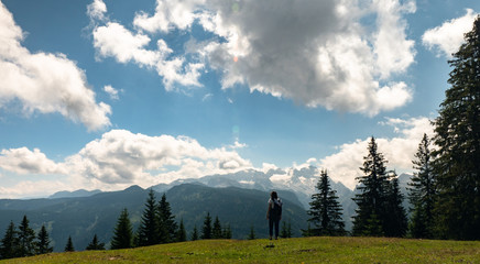 Young girl standing on a meadow in salzburger land austria with beautiful view to the mountains