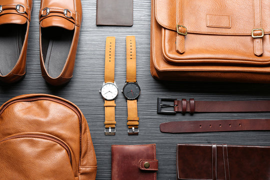 Flat lay composition with leather bags, shoes and accessories on grey wooden table