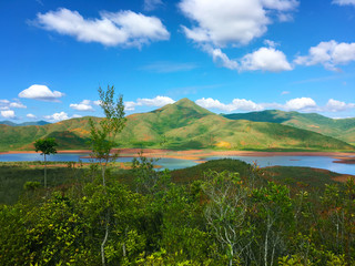 Fototapeta na wymiar Lake with submerged forest inside the Riviere Bleue Park in New Caledonia. The lake is surrounded by high green mountains and a dense forest with numerous streams of water.