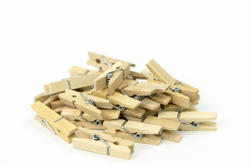 bunch of wooden clothespins piled up in mess on white background close up . beech wood, natural...