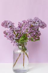 Bright blooms of spring lilacs on a table in house. Spring purple flowers close-up. Selected focus.