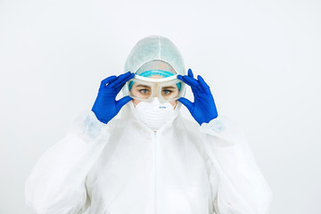 portrait of tired doctor after shift in the hospital. The doctor in protective clothing - glasses, mask, gloves on white background. The doctor treating patients with coronavirus. Covid-2019