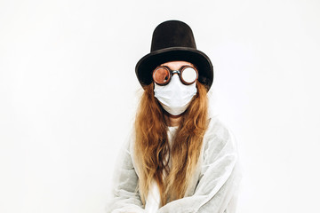 Creative girl in a white robe, medical mask, glasses and a hat on a white background. Self-isolation during coronavirus quarantine. Epidemic covid-2019.