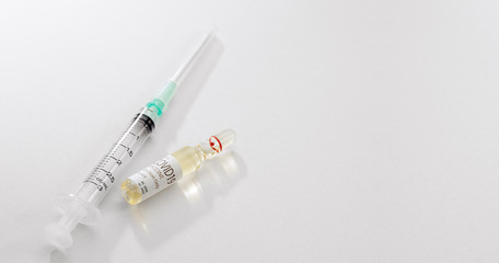 Close up view of the ampule with medicine and syringe on white back 