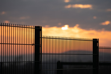 Private area fence on sunset background