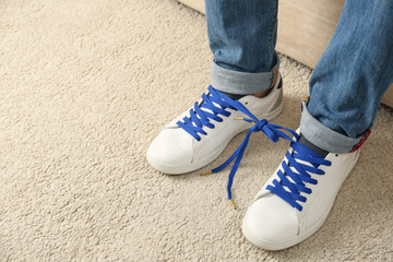 Man wearing sneakers with tied together laces, closeup. April fool's day