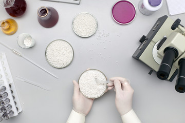 A laboratory assistant in protective gloves is conducting an experiment