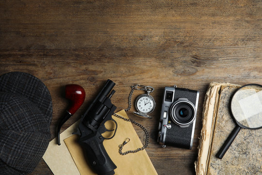 Flat lay composition with vintage detective items on wooden background, space for text