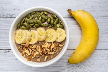 Chocolate smoothie bowl (Chocolate , avocado , banana , almond milk) topped with sliced banana, Pumpkin seeds, chopped  nuts and sesame seeds.