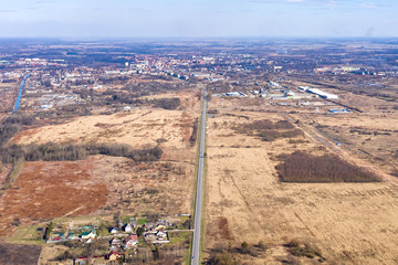 View from the height of the highway in the fields leading to the city, which is visible in the...