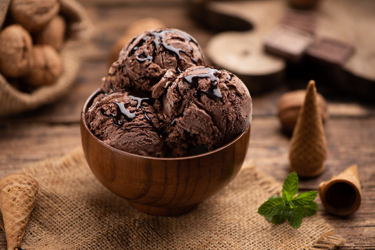 Bowl of chocolate and hazelnut ice cream on wooden table