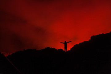 A tourist standing at the egde of the volcano