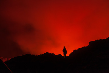 A tourist standing at the egde of the crater of volcano in Virunga National Park