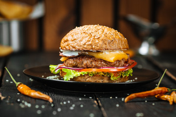 Tasty cheeseburger on a dark wooden background