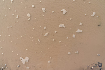 Close up of dirty puddle on earth road.