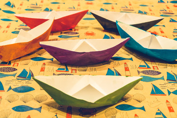 Multicolored paper boats on cartoon background symmetrically arranged