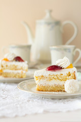 Slice of cake with cream and fruits on white background. Tea time. Selective focus