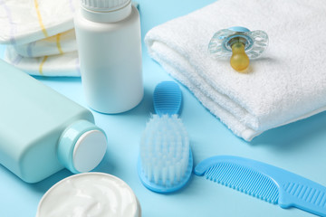 Fototapeta na wymiar Baby hygiene accessories on blue background, close up