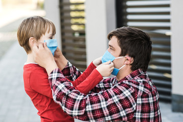 Father puts on son face mask outdoors. Coronavirus quarantine. Coronavirus outbreak.