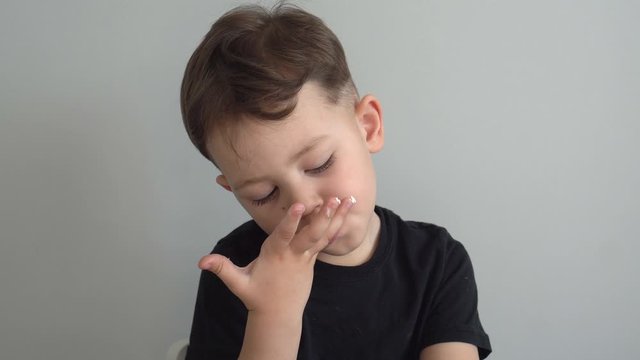the little boy licks his fingers