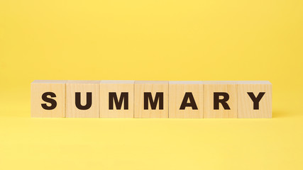 summary inscription on wooden blocks on yellow background