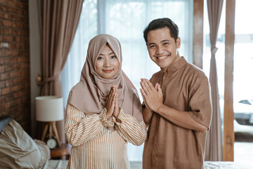 marhaban ya ramadhan. muslim couple welcoming ramadan month smiling to camera