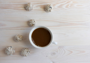 Fototapeta na wymiar Healthy breakfast concept, energy balls or protein bars and a cup of cappuccino on a wooden background, copy space, horizontal orientation, flat lay, healthy snack for vegans