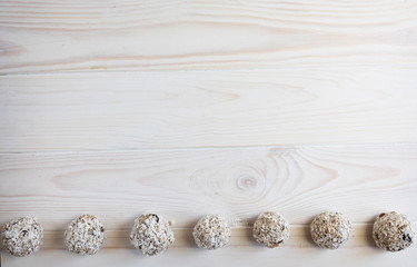 Energy balls using oatmeal and honey lie in a row on a light wooden background, copy space, top view