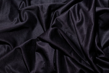 black wavy fabric background close-up. copy space