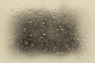 Drops of water on the misted glass. Toned photo, soft focus. Original vintage background with vignetting.