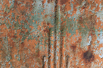 Aqua green paint, checked and crazed, flaking off a rusty metal background, horizontal aspect
