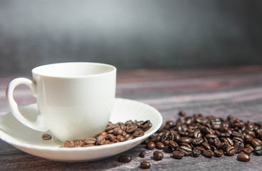 Coffee beans in a coffee cup on a wooden background