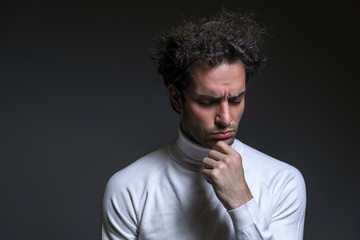 Portrait of an excited casual curly man with new ideas standing with raised hand